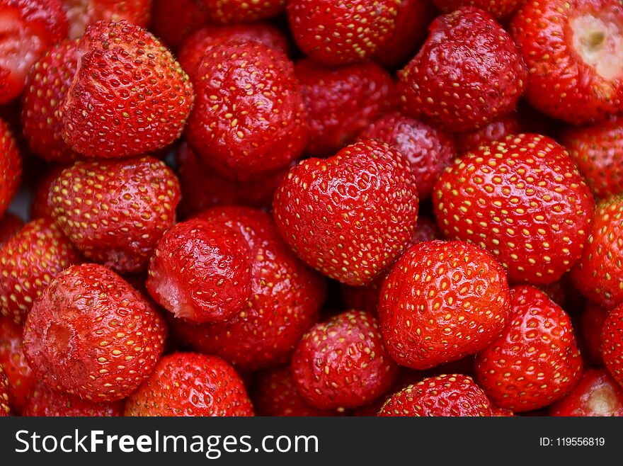 Red vegetable background of ripe strawberry berries in a heap. Red vegetable background of ripe strawberry berries in a heap