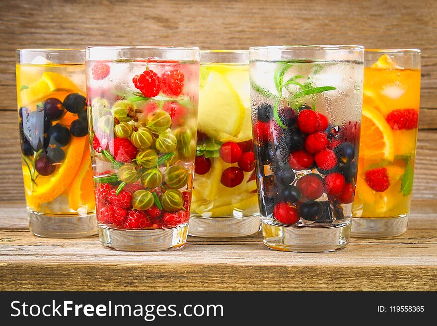 Various detox water in glasses, different tastes, berries, fruits.