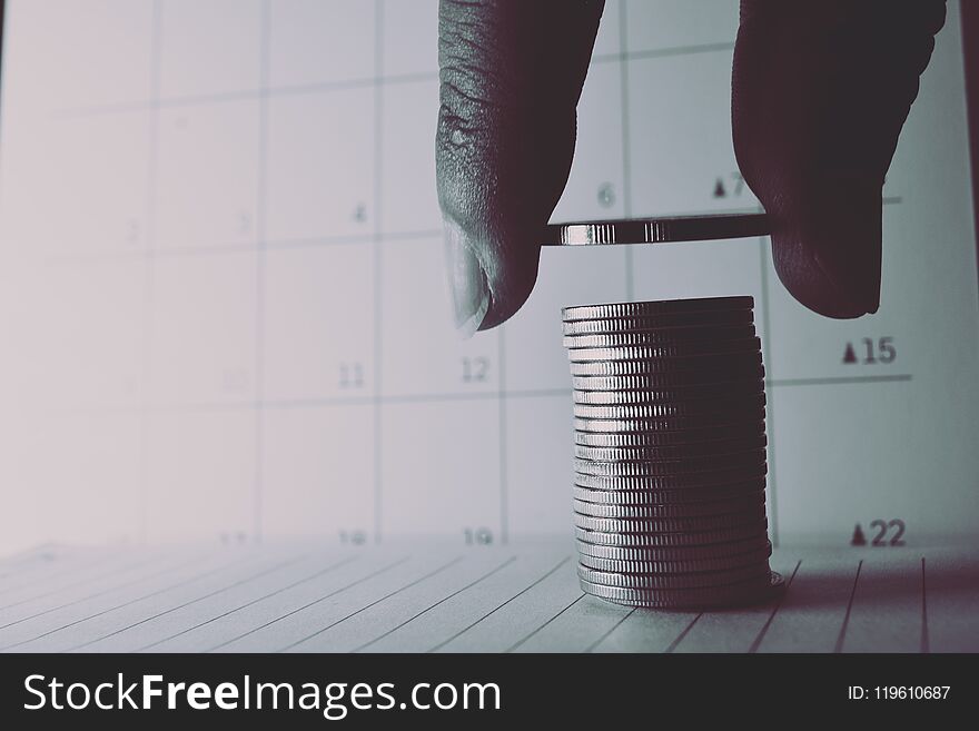 Men hand are sorted silver coins on calendar background and black and white. Men hand are sorted silver coins on calendar background and black and white.