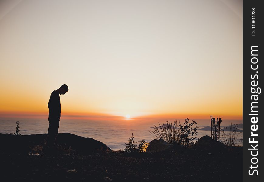 Silhouette Of Man Standing Near Sea During Golden Hour