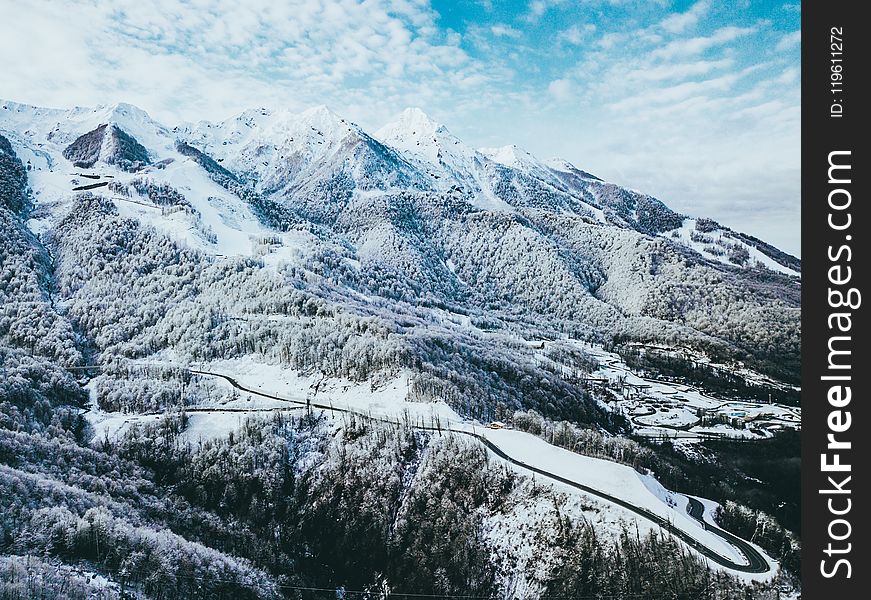 Mountains Covered In Snow Under Cloudy Sky