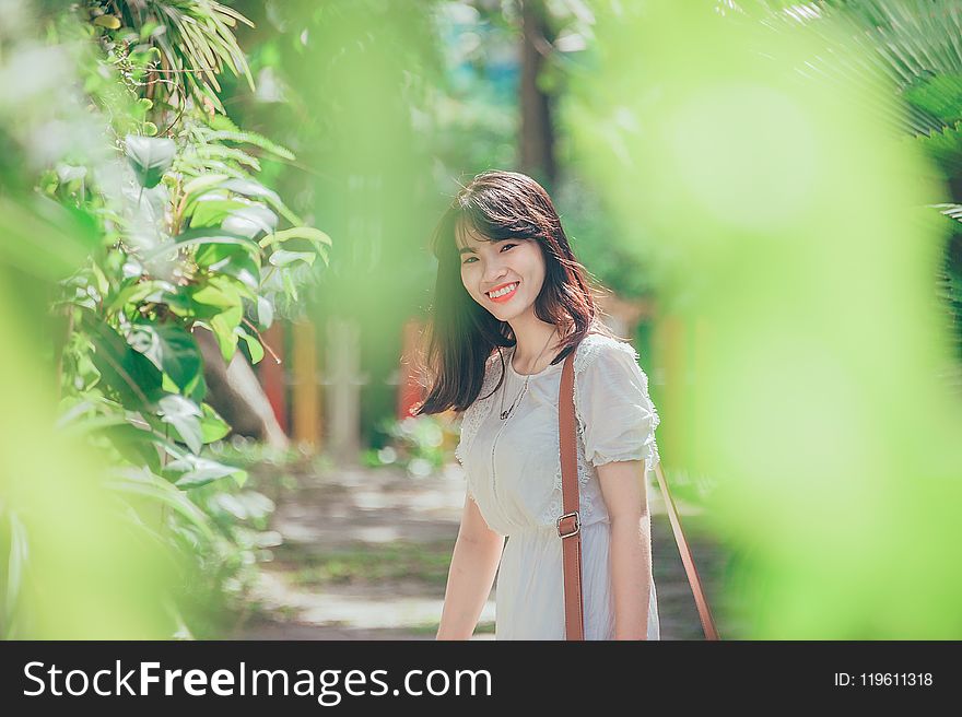 Woman Standing Nearby Green Leafed Plant
