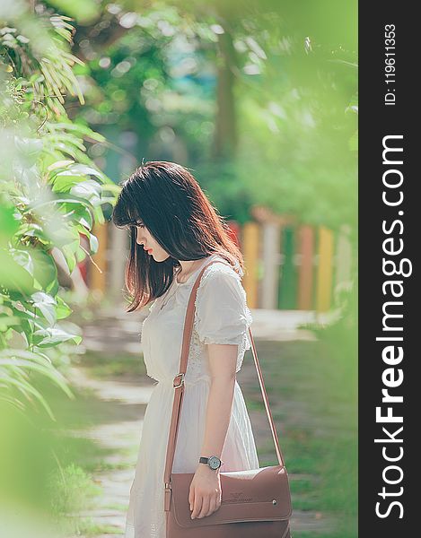 Woman Wearing White Crew-neck Short-sleeved Dress Standing Beside Green Leaf Plant
