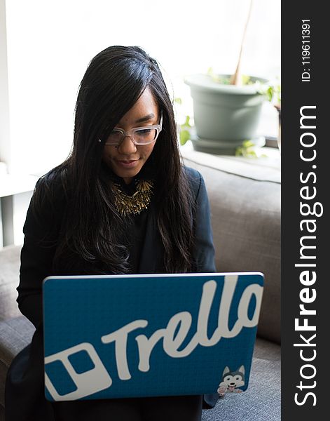 Woman in Black Coat Holding Her Blue Laptop Computer