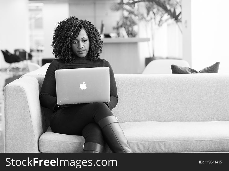 Woman Sitting on Couch Using Macbook
