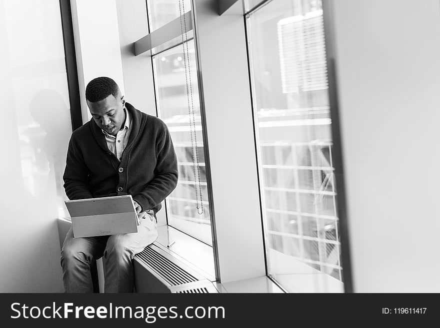 Grayscale Photo of Man Using Laptop