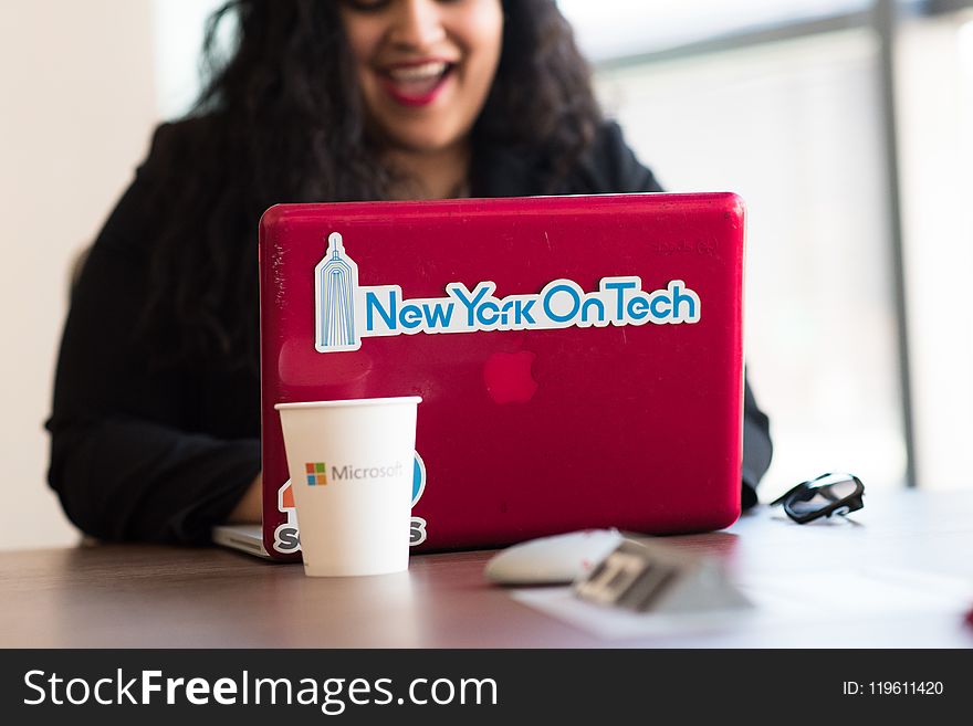 Selective Focus Phot of Woman Typing on Red Macbook