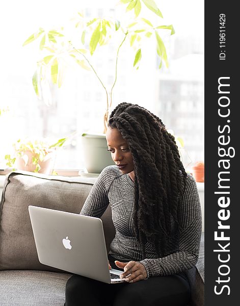 Woman in Gray Sweater Using Macbook Pro
