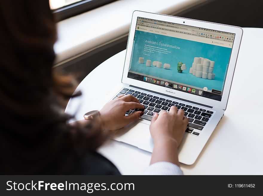 Woman Sitting Near Table Using Macbook