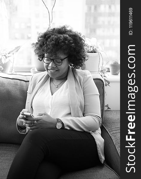 Grayscale Photo of Woman Sitting on Couch