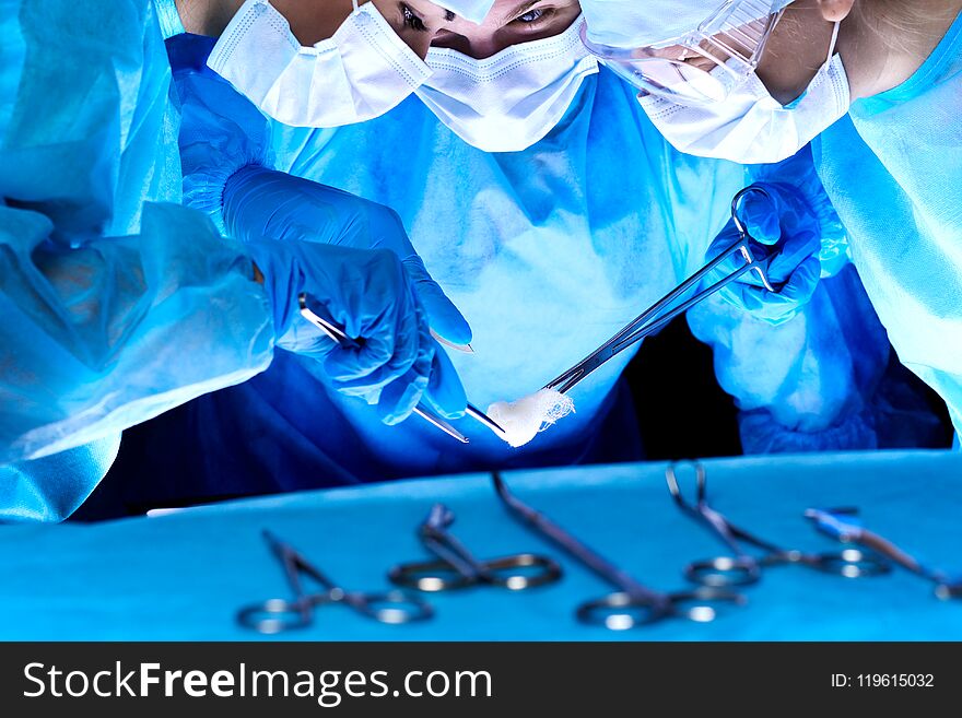 Group of surgeons in masks performing operation. Medicine, surgery and emergency help concepts