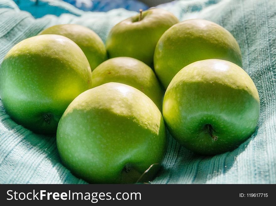 Pile of ripe green apples close up background.