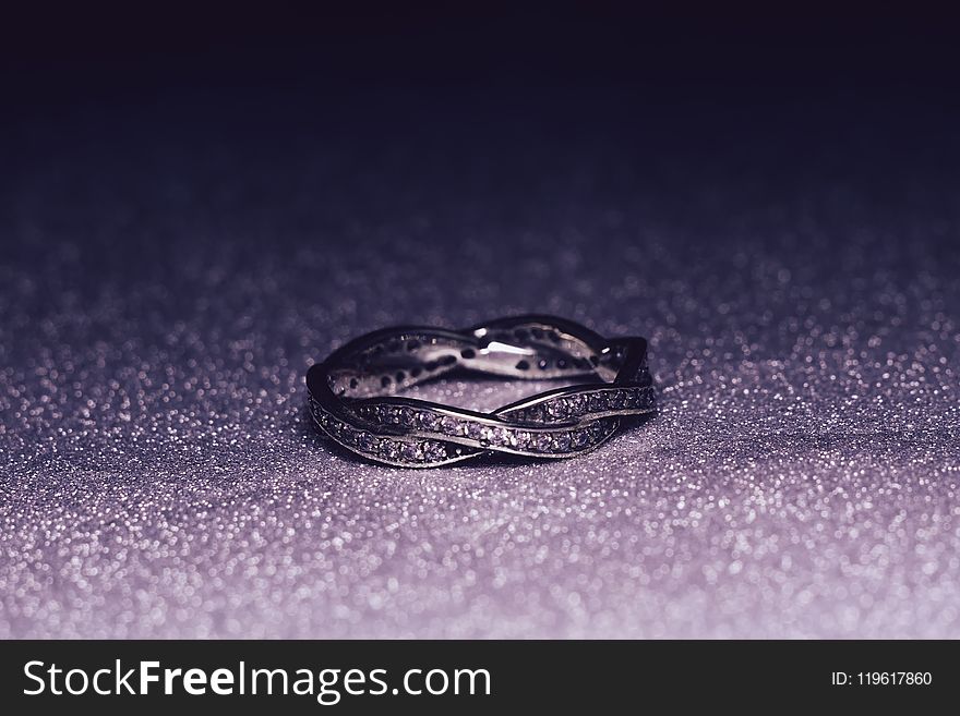 Fashion silver ring over glittering background, macro. Fashion silver ring over glittering background, macro.