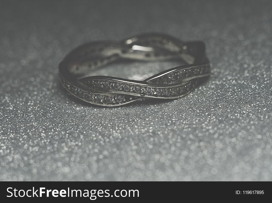 Fashion silver ring over glittering background, macro. Fashion silver ring over glittering background, macro.