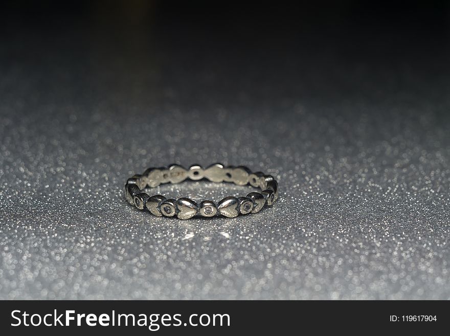 Fashion silver ring over glittering background, macro. Fashion silver ring over glittering background, macro.