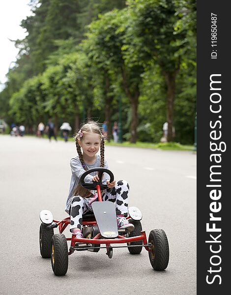Little girl in racing car amusemant park