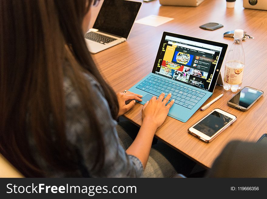 Woman in Gray Long-sleeved Top Using Laptop