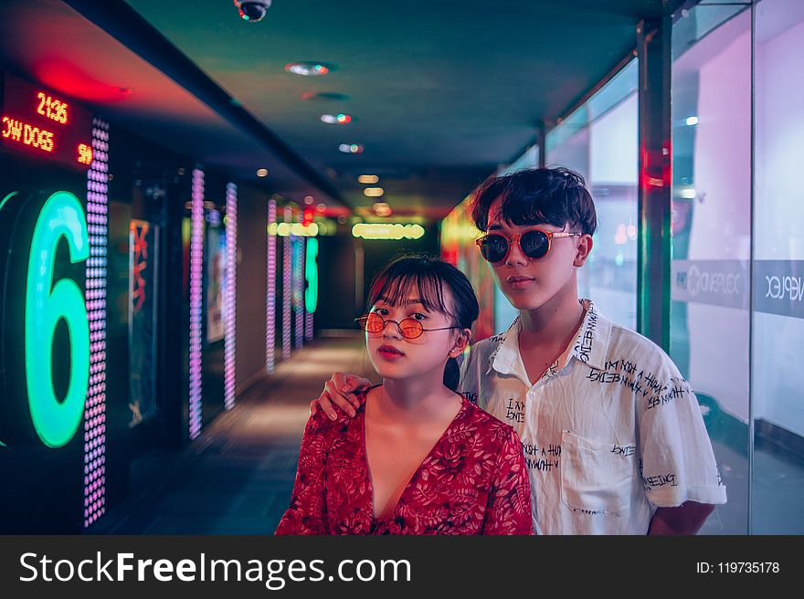 Two Man and Woman Wearing Sunglasses Inside Building