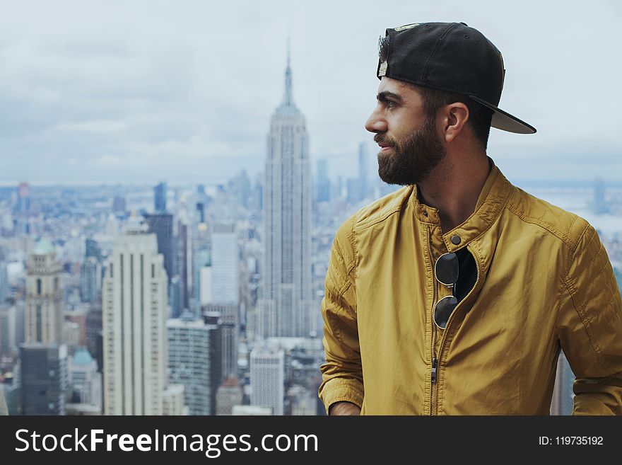 Portrait Photo of Man in Yellow Zip-up Jacket Near Empire State Building