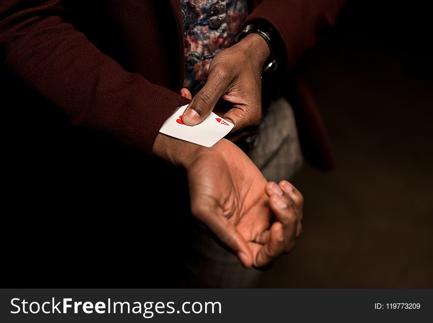 cropped view of african american man with ace in sleeve