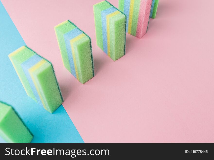 line of colorful washing kitchen sponges, on blue