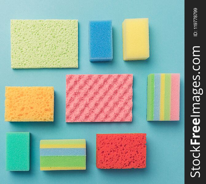 top view of background with colorful washing sponges, on blue