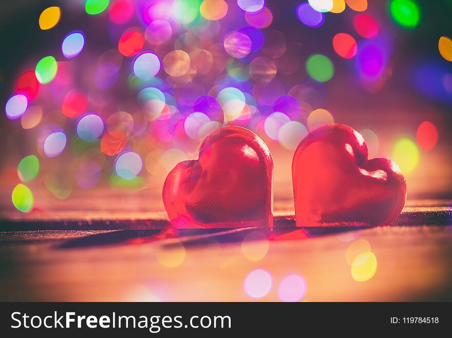 Red little decorative hearts on wooden background with amazing bokeh lights. Love or romantic Valentine day concept. Toned.