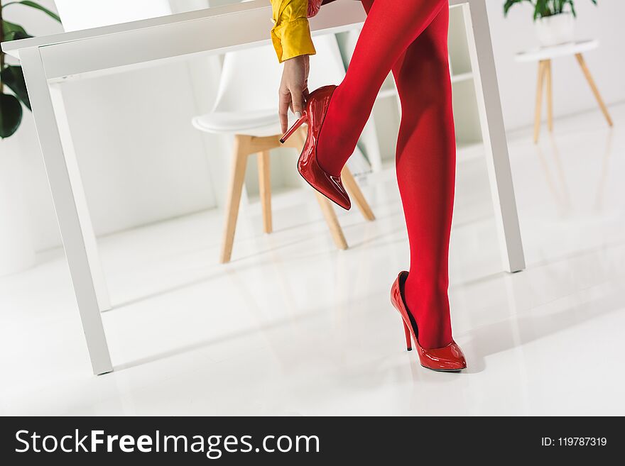 cropped view of stylish woman in red tights and heels