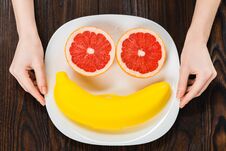 Cropped Shot Of Woman Holding Plate With Halved Grapefruit And Banana Case Royalty Free Stock Photos
