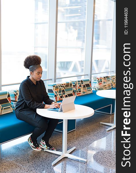 Woman in Black Outfit Working on a Laptop.