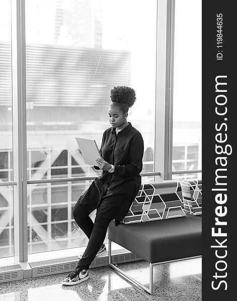 Woman Sitting On Sofa Looking At Book