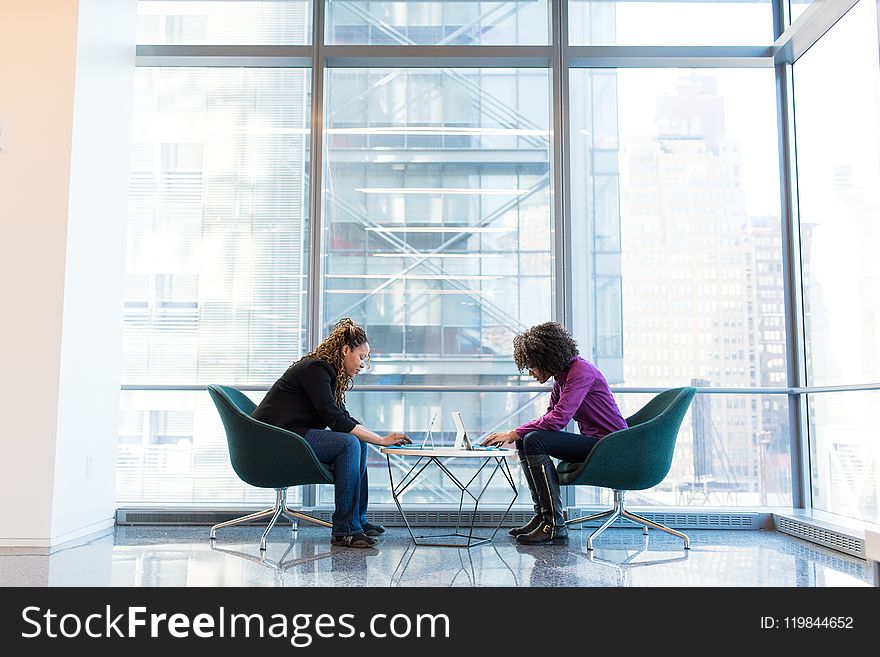 Two Woman Sitting Near Green Padded Chair