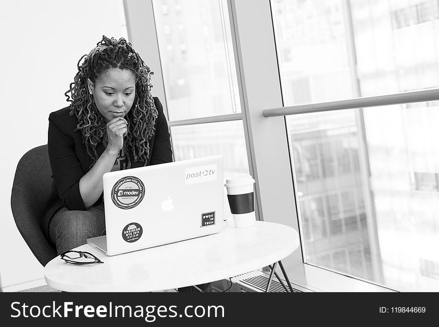 Grayscale Photo of Woman Facing Macbook