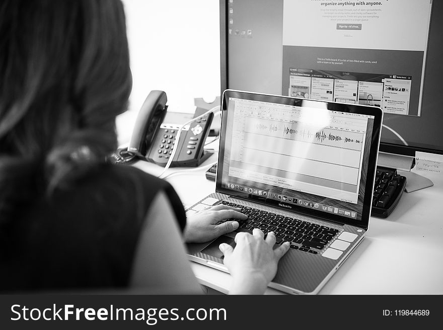 Grayscale Photo of Woman Using Macbook Pro