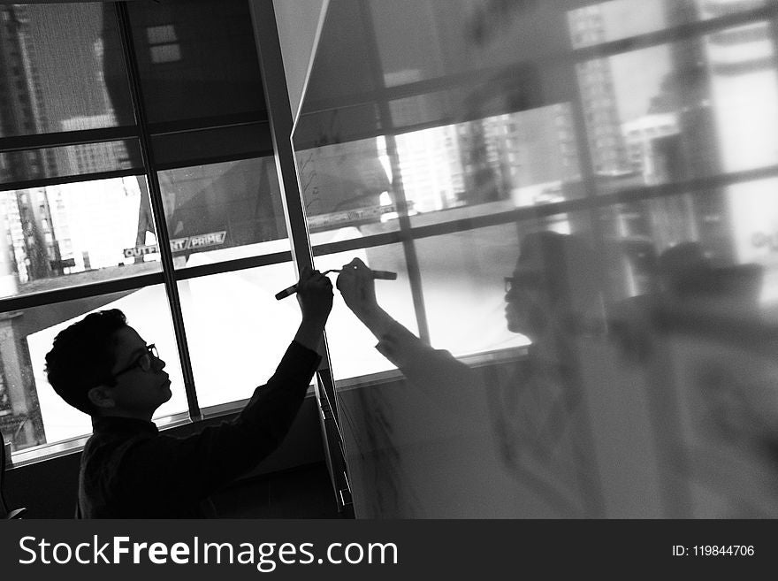 Grayscale Photo Of Man Holding Pen