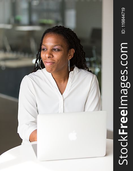 Woman Wearing White Button-up Shirt Sitting In Front Of Table