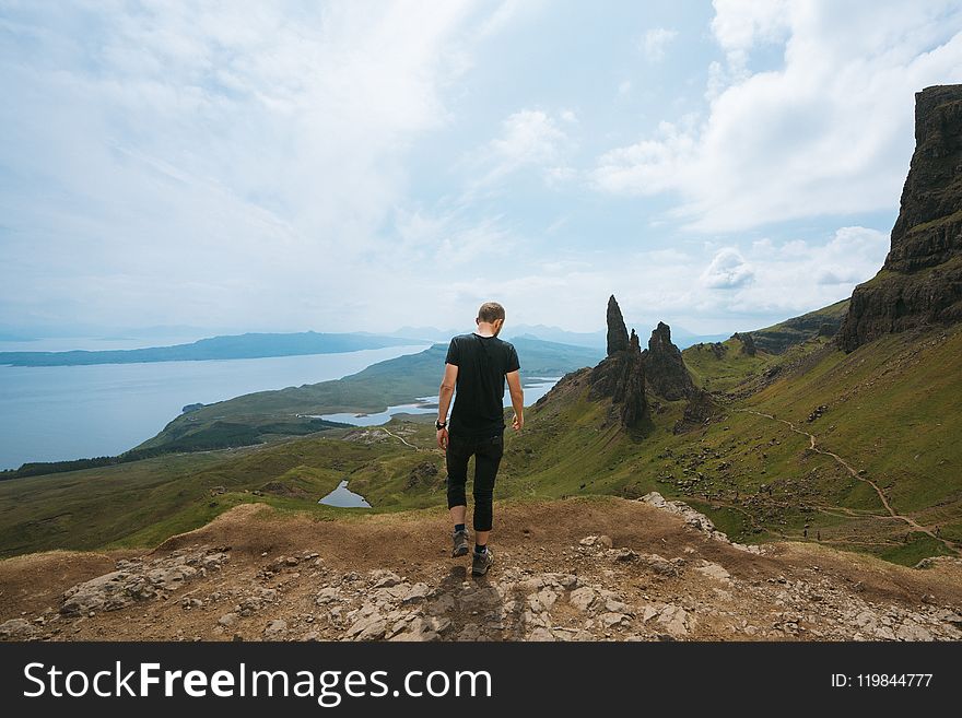 Man Wearing Black T-shirt Standing On Cliff