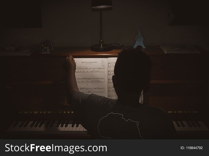 Photo of Person Sitting In Front Of Piano