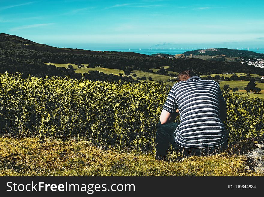 Person Sitting On Grass Field