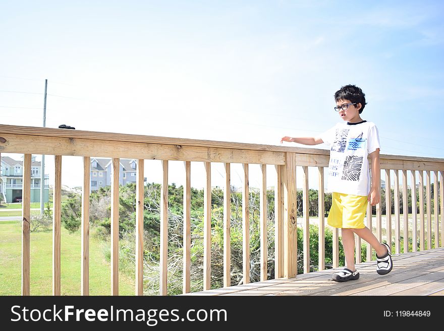Boy Walking on Wooden Bridge.