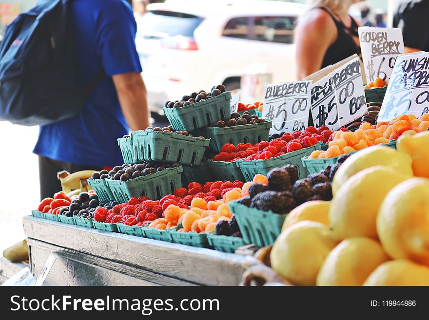 Man Wearing Blue Top and Black Bottom Standing Near Fruit Stand