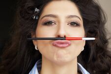 Young Model Holds A Makeup Brush In The Form Of A Mustache In Hairstyle And Makeup Salon. Little Fun During The Long Royalty Free Stock Photos