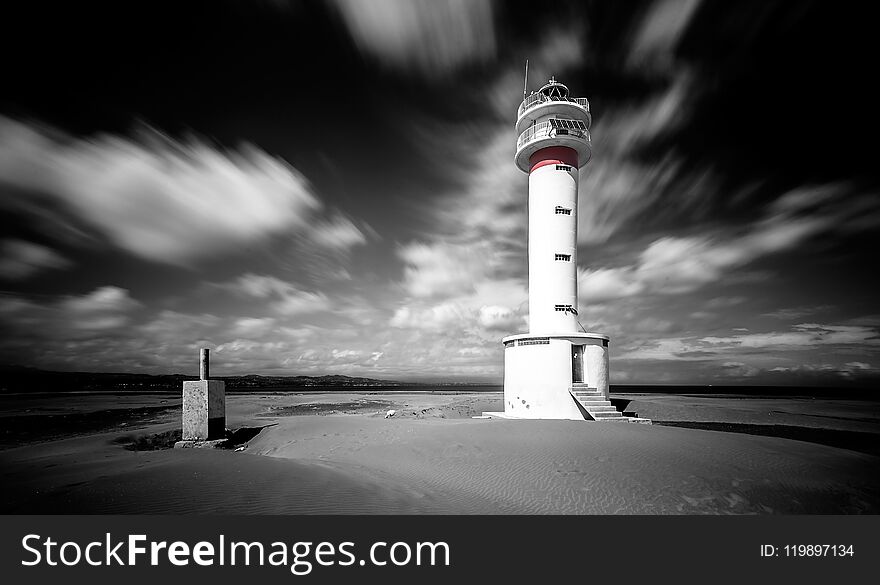 Far del Fangar lighthouse, with clouds in motion B&W. Estuary of the Ebro river, Tarragona Spain. Far del Fangar lighthouse, with clouds in motion B&W. Estuary of the Ebro river, Tarragona Spain.