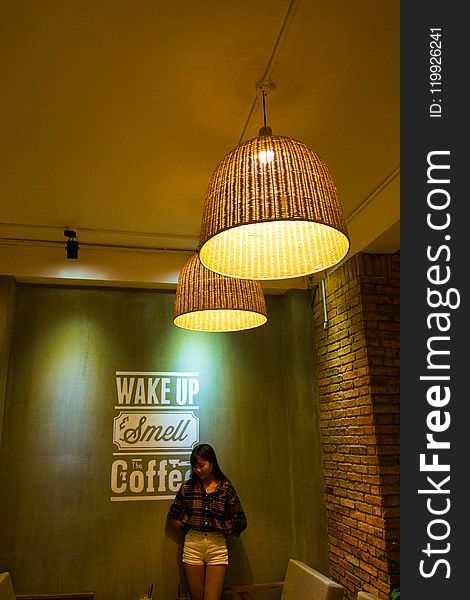 Woman Standing and Leaning Beside Wake Up Smell the Coffee Text Wall