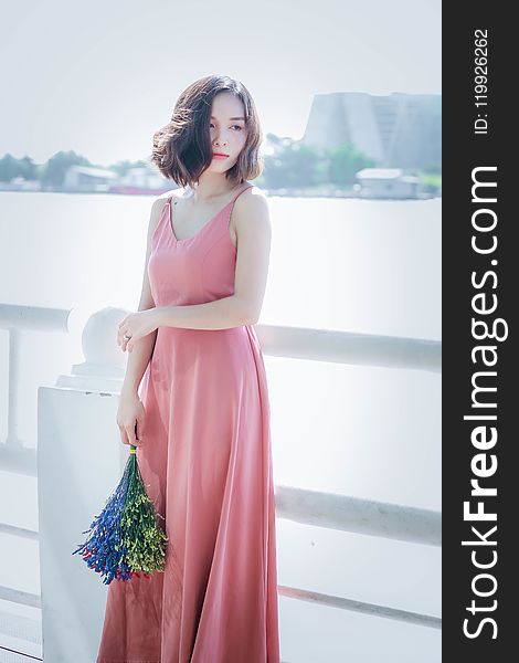 Woman Wearing Pink Spaghetti Strap Maxi Dress Holding Flowers