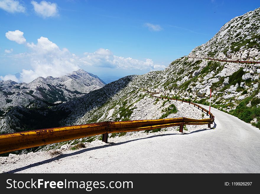 Photo of Narrow Paved Mountain Road with Barrier.