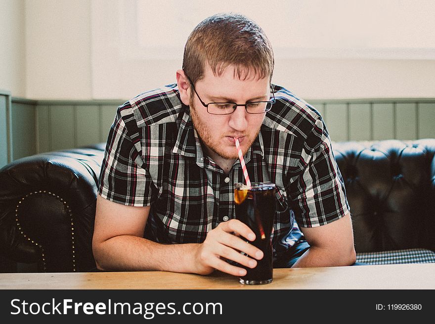 Man Sipping Drink From Clear Glass