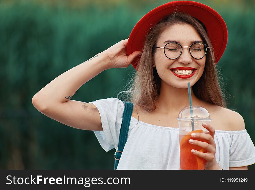 A Young Stylish Woman Having A Refreshing Drink While Walking