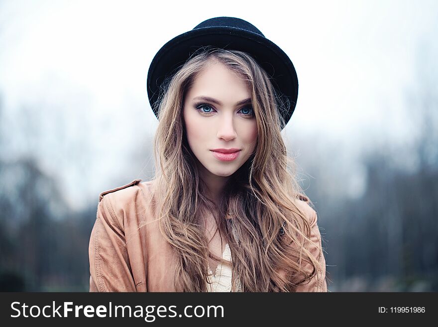 Beautiful young woman outdoors in park. Perfect female face closeup