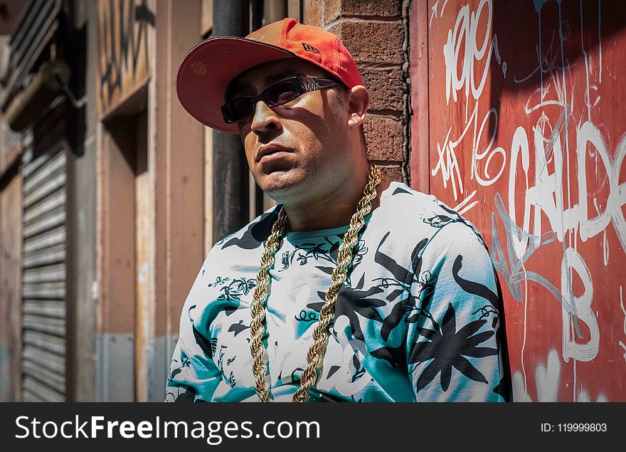Photo of Man Wearing Black and White Cannabis Print Top and Gold-colored Necklace